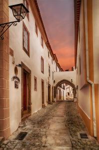 un callejón en un casco antiguo con un arco en Estalagem de Marvão en Marvão