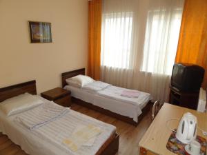 a hotel room with two beds and a television at Sia Rebir D, Hotel Rebir in Daugavpils
