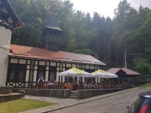 a restaurant with tables and umbrellas in front of a building at Hotel Stavilar in Sinaia