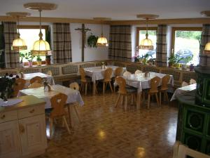 ein Esszimmer mit Tischen und Stühlen in einem Restaurant in der Unterkunft Haus Bergheimat in Kals am Großglockner