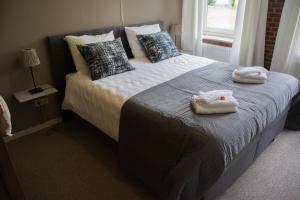 um quarto com uma cama com toalhas em Erve de Bosch em Benteloo