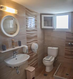 a bathroom with a sink and a toilet and a mirror at Hotel Antiparos in Antiparos