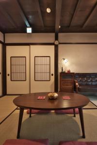 un soggiorno con un tavolo e un divano di Kanazawa Guest House East Mountain a Kanazawa