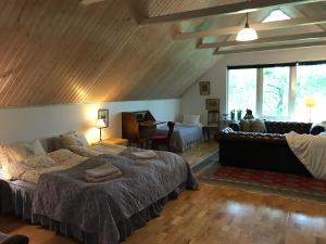 a bedroom with a large bed and a living room at Karlsborg Rum och Frukost in Ystad