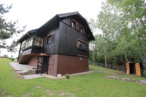 a house with a black roof and a green yard at Holiday Home Winzerhaus Eva in Špičnik