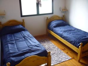 2 camas individuales en una habitación con ventana en Cabaña Lecalau en Lago Puelo