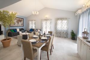 a dining room and living room with a table and chairs at Country Style Villa Christina in Pouláta