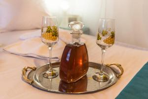 two wine glasses and a bottle on a tray at Studios Elina in Skala Potamias