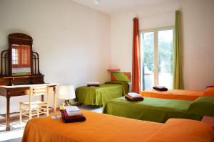 マルサラにあるGiardinello Stagnone Sunsetのベッド3台、デスク、窓が備わる客室です。