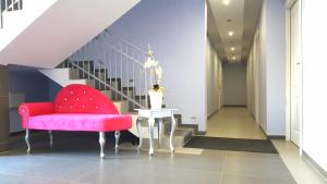 a red chair and a table in a hallway at Solar Bed & Breakfast in Karwia