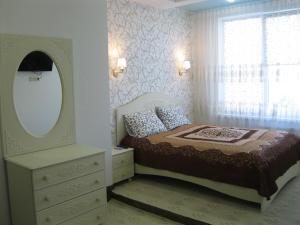 a bedroom with a bed and a dresser and a mirror at Apartment at Sadovaya 27 in Yalta