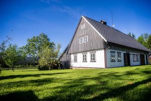 a white house with a gambrel roof on a grass field at Chalupa Přeslička in Rejvíz