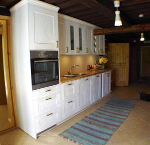 Pällu的住宿－Väike-Pällo Holiday Home，厨房配有白色橱柜、水槽和微波炉