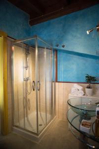 a bathroom with a shower and a glass table at Terra di Mezzo in Collepasso