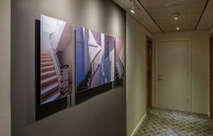 a hallway with four paintings on the wall at Prima Tel Aviv Hotel in Tel Aviv