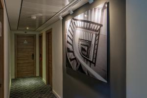 a hallway with a painting of stairs on the wall at Prima Tel Aviv Hotel in Tel Aviv
