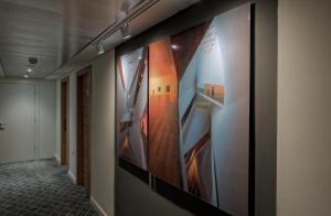 a hallway with paintings of stairs on the wall at Prima Tel Aviv Hotel in Tel Aviv