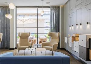 a living room with two chairs and a blue couch at Prima Tel Aviv Hotel in Tel Aviv