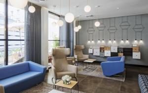 a waiting room with a blue couch and chairs at Prima Tel Aviv Hotel in Tel Aviv