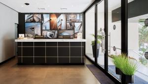 a home entry with a black and white kitchen with plants at Prima Tel Aviv Hotel in Tel Aviv
