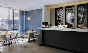 a restaurant with a counter and tables and chairs at Prima Tel Aviv Hotel in Tel Aviv