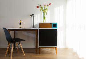 a desk with a computer and a vase on top of it at Prima Tel Aviv Hotel in Tel Aviv