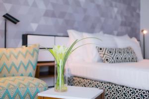 a vase with a flower on a table next to a couch at Prima Tel Aviv Hotel in Tel Aviv