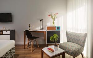 a living room with a desk and a chair at Prima Tel Aviv Hotel in Tel Aviv