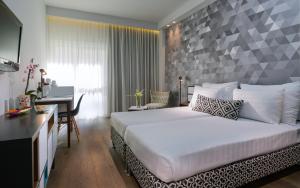 a hotel room with a bed and a desk and a desk at Prima Tel Aviv Hotel in Tel Aviv