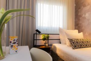 a hotel room with two beds and a window at Prima Tel Aviv Hotel in Tel Aviv
