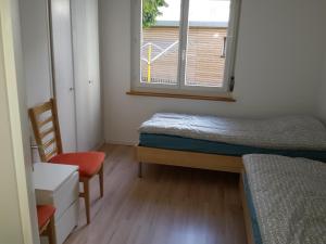 ダボスにあるFerienwohnung Sesvenna Davosのベッド2台と窓が備わる小さな客室です。