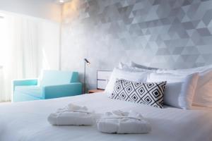 a bedroom with a white bed with two towels on it at Prima Tel Aviv Hotel in Tel Aviv