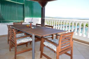 uma mesa de madeira e cadeiras numa varanda em Boa Vista em São Bartolomeu de Messines