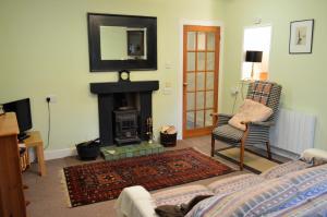 a living room with a fireplace and a couch at Trevenek Cottage in Kilmartin