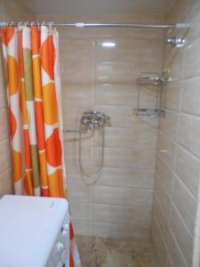 y baño con ducha y cortina de ducha de color naranja y blanco. en Guesthouse on Benashvili en Tiflis