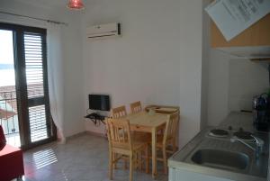 eine Küche mit einem Tisch, Stühlen und einem Waschbecken in der Unterkunft Apartment familie in Prizna