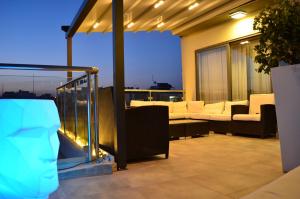 a balcony with couches and chairs on a building at Paramount Bay Penthouse in Birżebbuġa