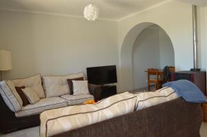 a living room with two couches and a tv at Boa Vista in São Bartolomeu de Messines