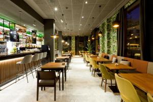 un restaurante con mesas y sillas de madera y un bar en Hotel Malcom and Barret, en Valencia