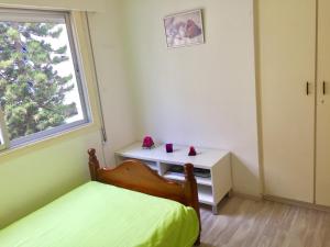 a bedroom with a bed and a desk and a window at Sea View Apartment in Limassol