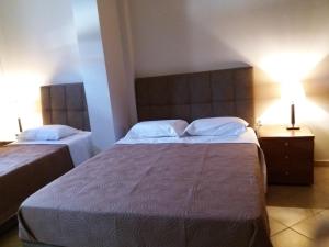 a hotel room with two beds and a lamp at Spyros Apartments in Argostoli