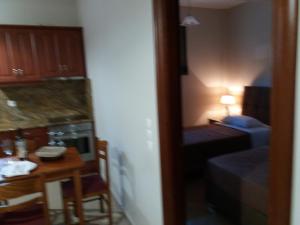 a room with a kitchen and a table and a small room with a table at Spyros Apartments in Argostoli