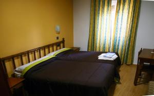 Een bed of bedden in een kamer bij Hostal Muralla