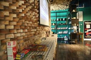 a room with a brick wall with books on a bench at Huashan Lotus International Hostel in Huayin