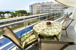a table and chairs on the balcony of a building at Central park Blanes in Blanes