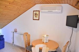 a dining room with a table and a tv at Apartments Bakuk in Stari Grad