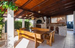 Un patio con mesa y sillas de madera y una cocina. en Apartments Alisa, en Brodarica