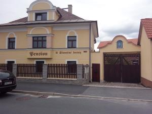 ein gelbes Haus mit einem Tor und einem Zaun in der Unterkunft U Slunecne brany in Franzensbad