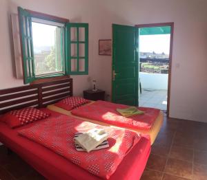 two beds in a room with a door and windows at Casa Andrés in Yaiza