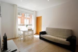 ein Wohnzimmer mit einem Sofa und einem Tisch in der Unterkunft Apartaments Claudia in Reus